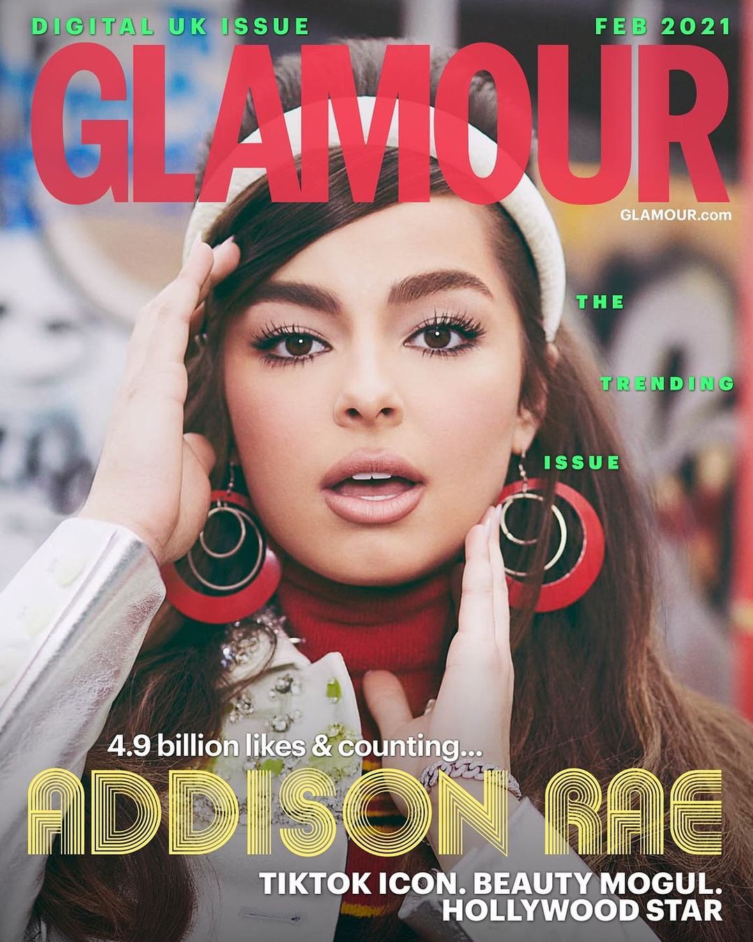 Glamour cover featuring Addison Rae, close-up portrait with hands near face, wearing red turtleneck, hoop earrings, and silver jacket.