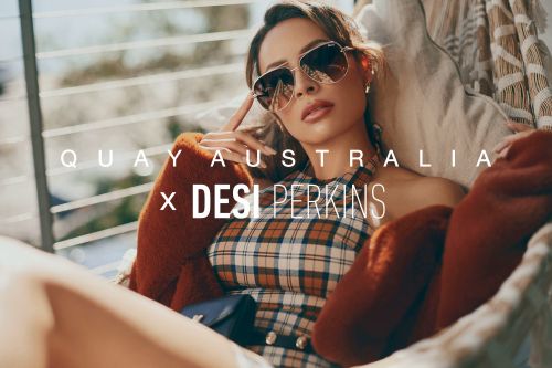 Glamorous woman in sunglasses and plaid dress, lounging casually in a stylish setting, bathed in soft, diffused sunlight.