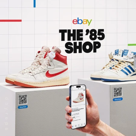 Ebay's '85 Shop showcases vintage high-top sneakers displayed on white pedestals, along with a mobile phone and a QR code.