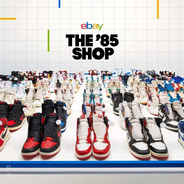 Numerous pairs of athletic shoes are displayed on a white surface in a grid pattern, with eBay and 'The 85 Shop' text visible above.