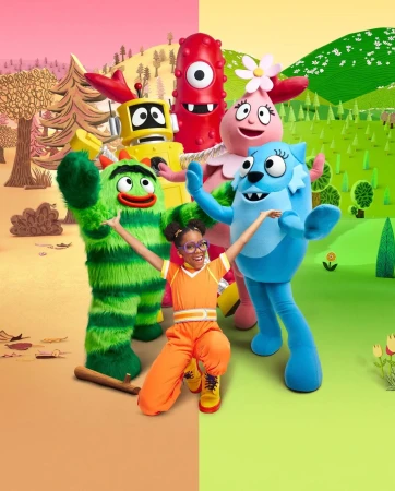 Human dressed in orange with Yo Gabba Gabba characters: Brobee, Foofa, Muno, and Toodee on a split tan and green cartoon landscape.