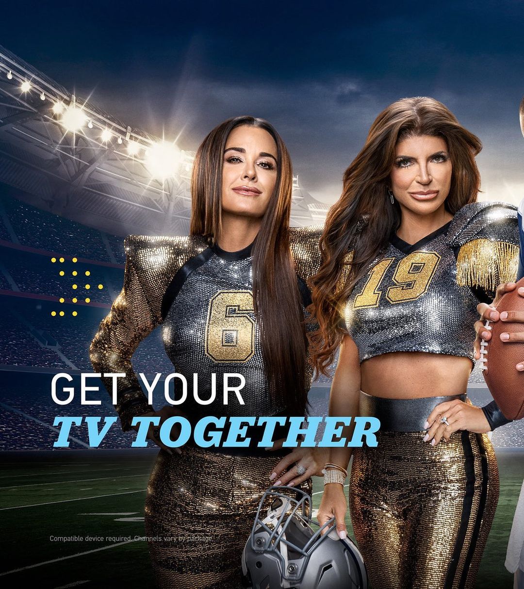 Two adult females wearing sports-themed apparel with football helmet, standing on a football field with stadium lights in the background.