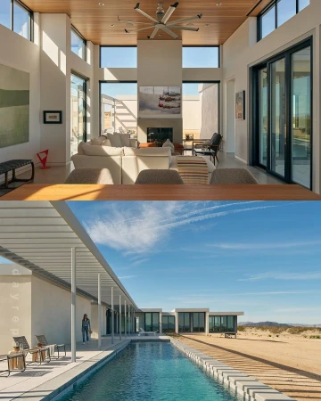Indoor living room with white sofa set, fireplace, art, ceiling fan, and floor-to-ceiling windows, and outdoor pool with modern building.