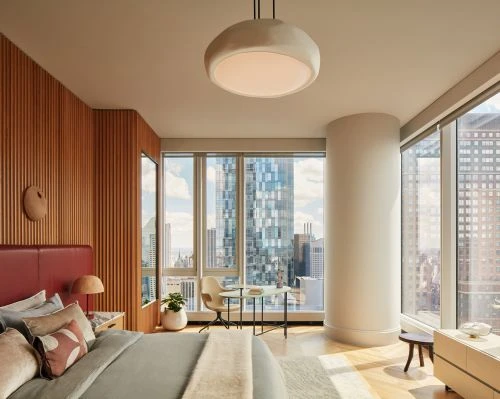 Modern bedroom interior with a large window offering a cityscape view, featuring a bed, minimalist furniture, and natural light.
