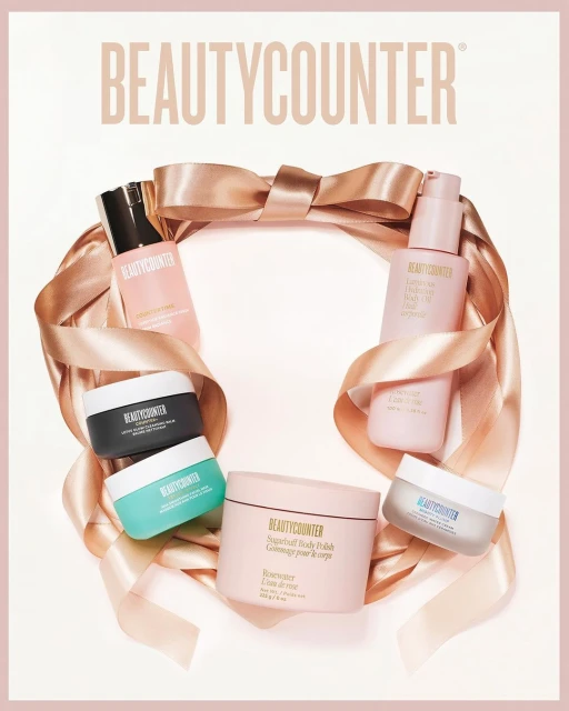 Beautycounter product display with skincare bottles, creams, and a peach satin ribbon on a white background in a promotional image.