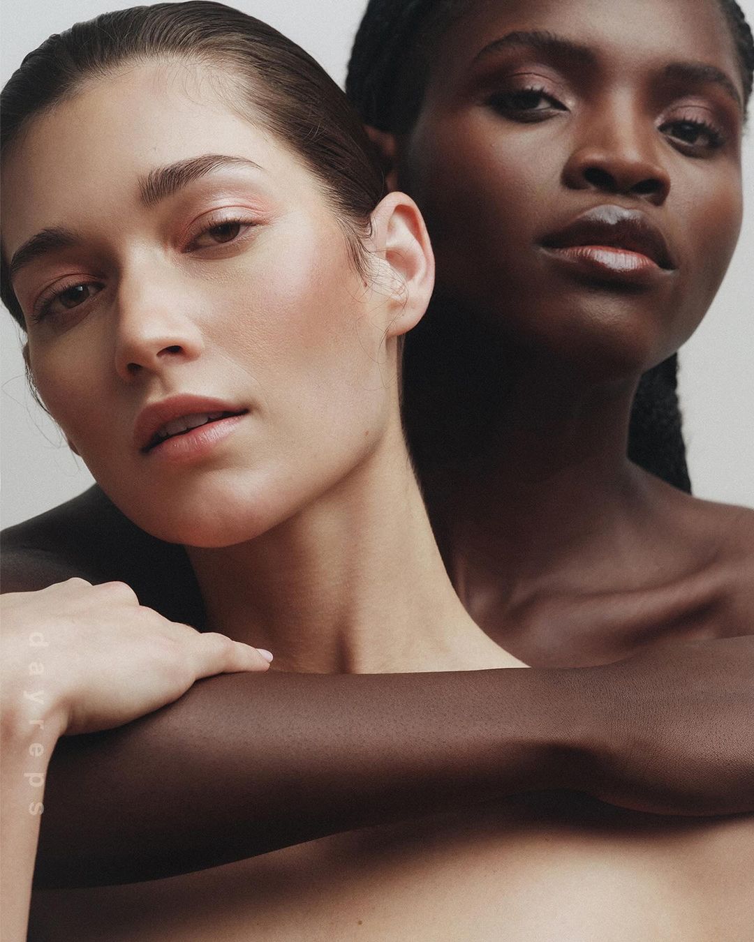 Close-up portrait of two women embracing against a neutral background, photographed by Wolfe + Von.