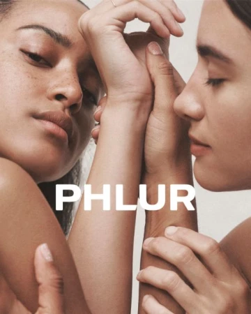 Close-up portrait of two women pressing hands and arms together against a neutral background with bold text