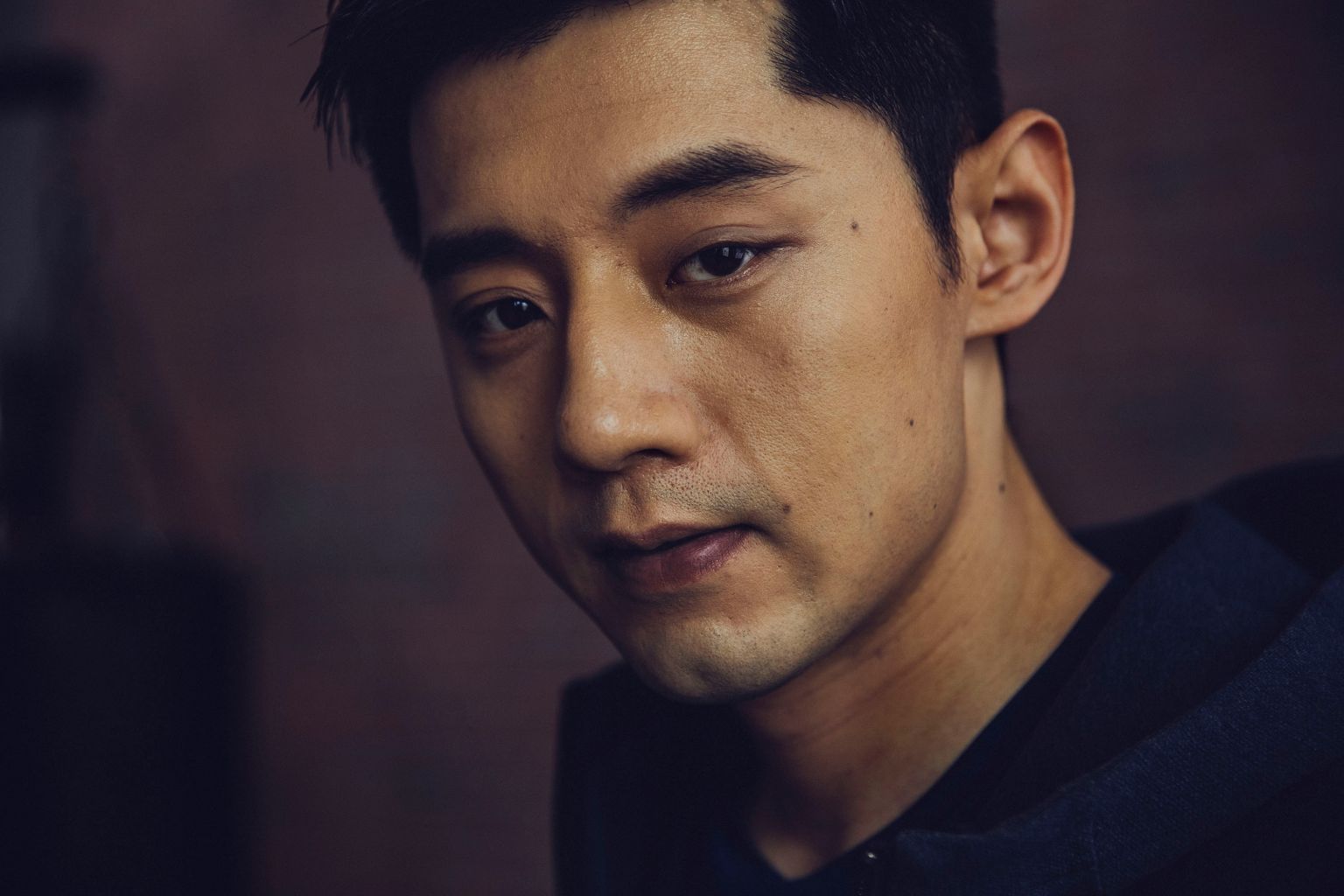 Close-up portrait of an Asian man looking forward with a serious expression by photographer Nick Laham