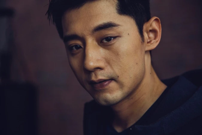 Close-up portrait of an Asian man looking forward with a serious expression by photographer Nick Laham