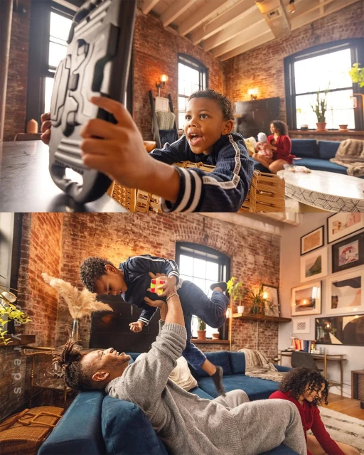 A young boy is playing a video game with a toy guitar in a brick-walled living room while his family relaxes on a blue couch in the background.
