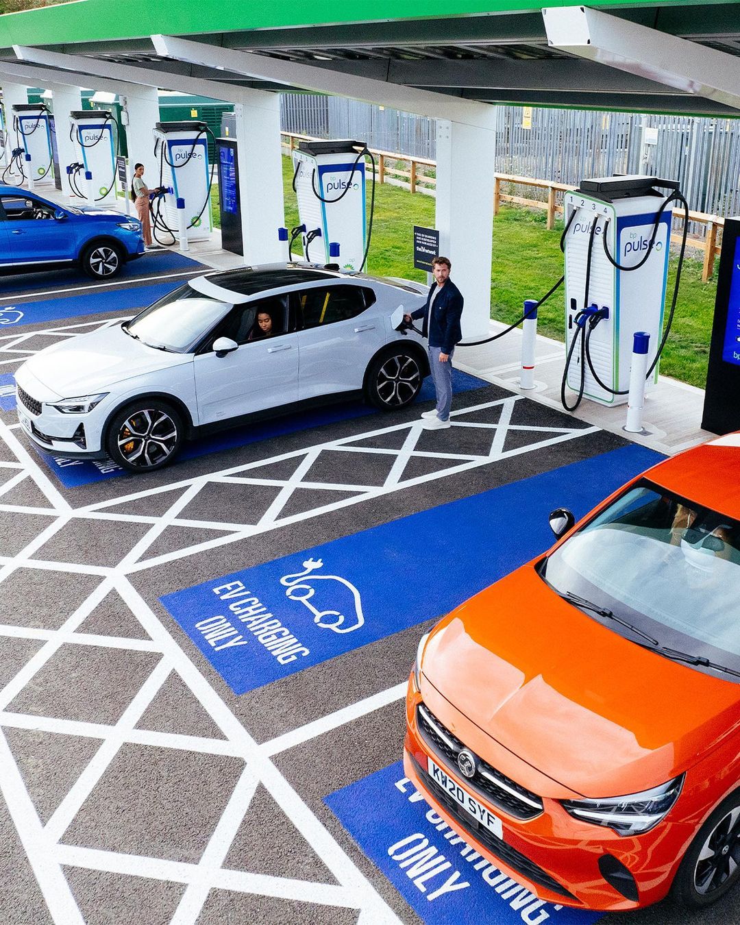 Multiple electric vehicles charging at a modern outdoor charging station, emphasizing sustainable transportation and innovative automotive technology.