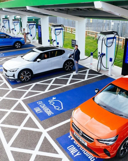 Multiple electric vehicles charging at a modern outdoor charging station, emphasizing sustainable transportation and innovative automotive technology.