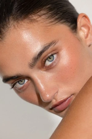 Close up beauty portrait of a woman with wet look hair and dewy skin captured by Ali Mitton