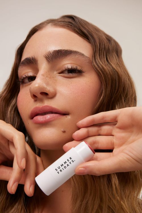 Close-up of a woman holding a Summer Fridays skincare product, showcasing beauty and skincare advertising with clear product visibility.
