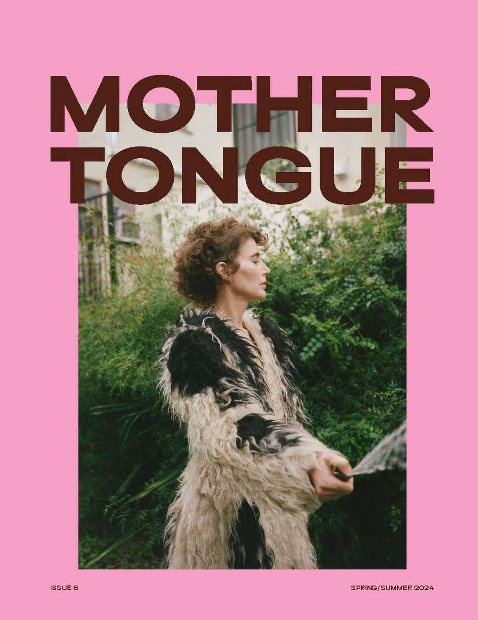 Woman in fluffy black and white coat outdoors against green foliage framed by bold pink typography reading MOTHER TONGUE.