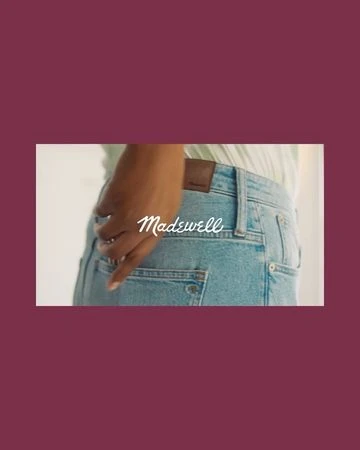 Close-up of an adult person wearing light wash jeans with their hand in the back pocket, featuring the Madewell brand label.