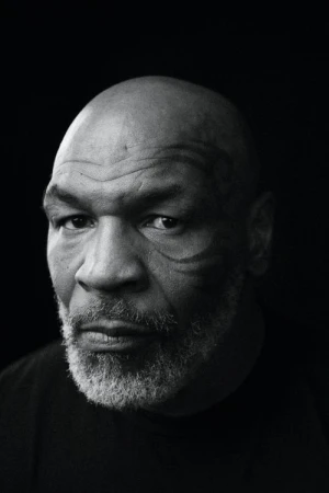 Black and white close-up portrait of a bald adult male with a gray beard and face tattoos against a solid dark background.