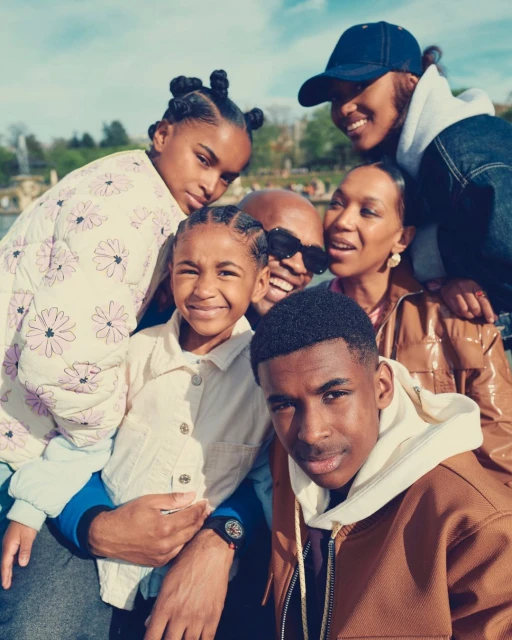 A group portrait features a family of six posing outdoors in a park-like setting. The shot includes parents, teen, and children smiling.