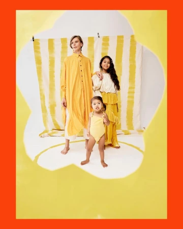 Group of three people in yellow clothing photographed through a jagged torn paper frame by Priscilla Gragg