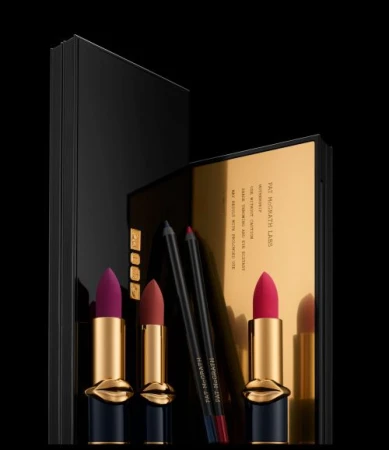 Pat McGrath Labs makeup set featuring three lipsticks and two lip pencils against a sleek black and gold background. Beauty and cosmetics.