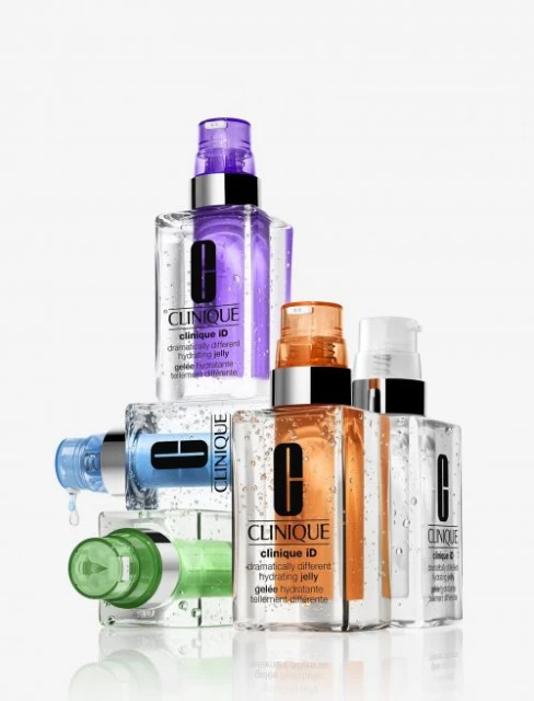 Stack of Clinique iD hydrating jelly skincare products in clear bottles with colorful pump tops on a white background. Beauty product shot.