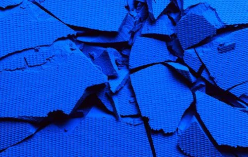 Crushed blue eyeshadow powder, showing textured surface in a vibrant monochrome palette for beauty and makeup concepts.