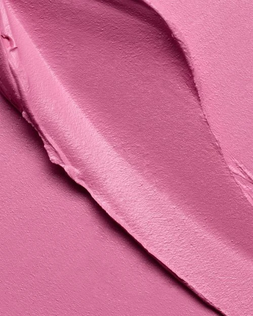 Close-up of pink cream texture with smooth, glossy surfaces and visible ridges, creating a visually soft and tactile impression.