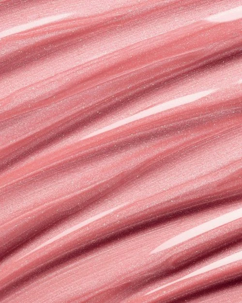 Macro image of shimmering, light pink lip gloss streaks, highlighting texture and reflective qualities, ideal for beauty or cosmetic themes.