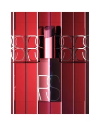 Close-up product shot of a metallic red lipstick tube against a glossy red reflective background