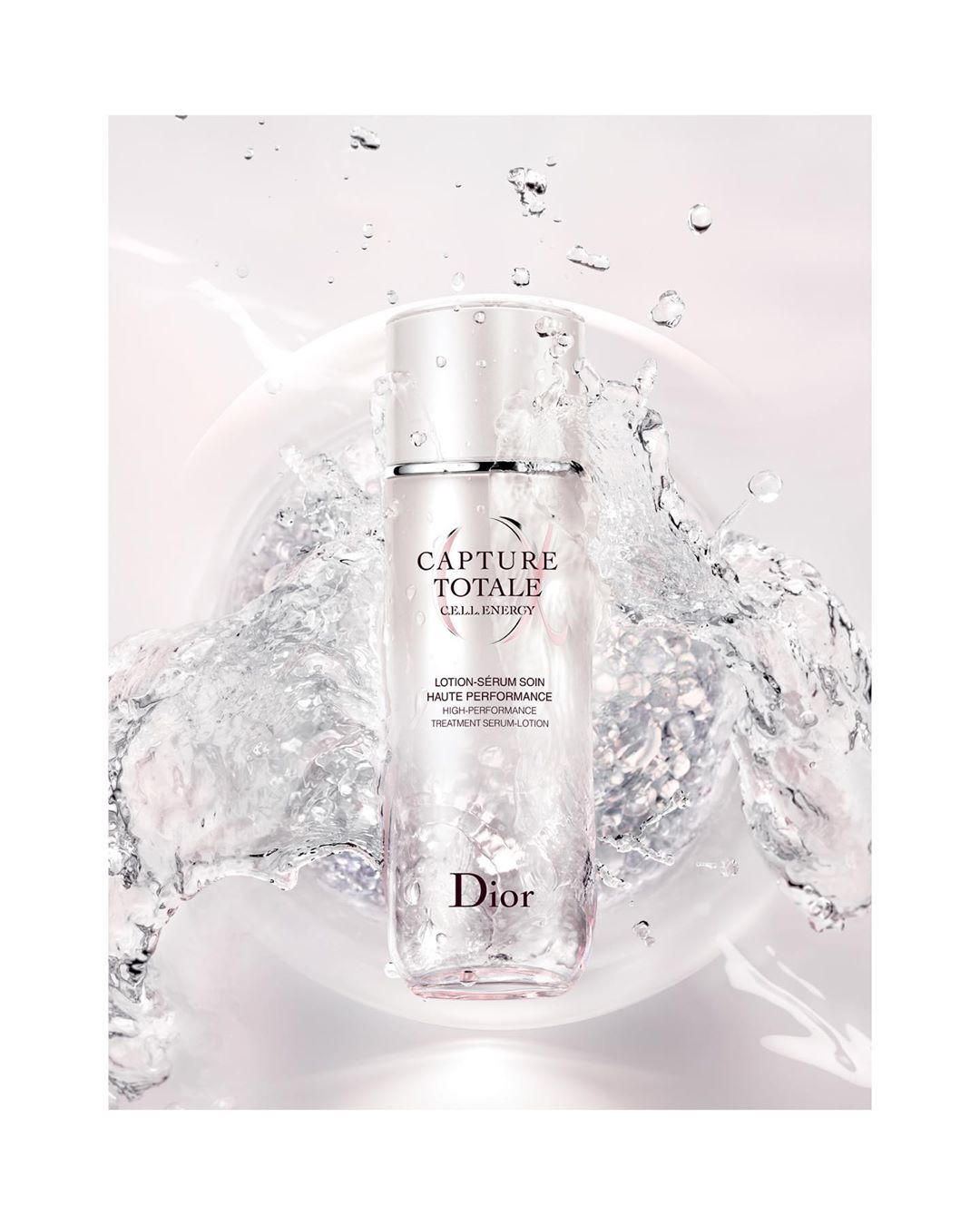 Dior Capture Totale skincare product bottle in clear packaging with water droplets on a white background for beauty advertising.