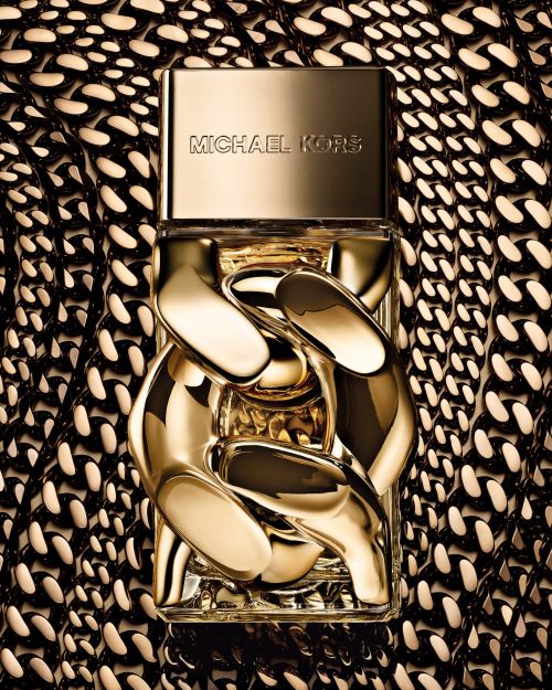 Michael Kors perfume bottle with a gold chain design set against a gold and black chain patterned background.
