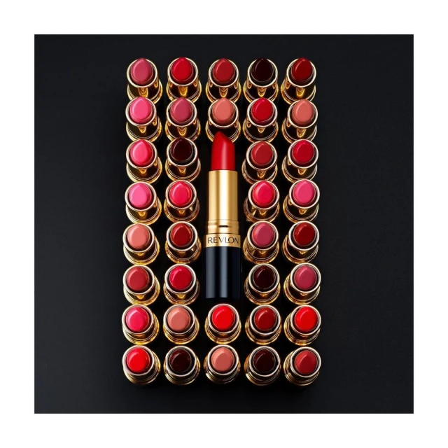 Arrangement of red and pink lipstick tubes with gold accents centered on a black background, providing a visually striking beauty product display.