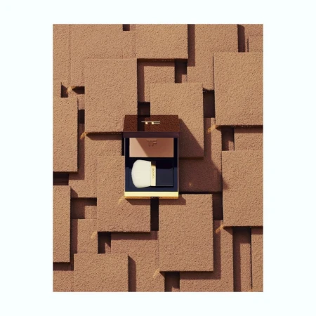Tom Ford bronzer compact with application brush sits against a geometric textured background of brown, tan, and off-white squares.