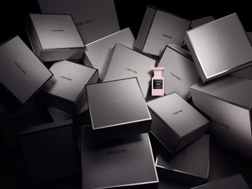 Tom Ford perfume bottle in pink among multiple grey Tom Ford boxes, product-focused and visually showcasing luxury beauty brand.
