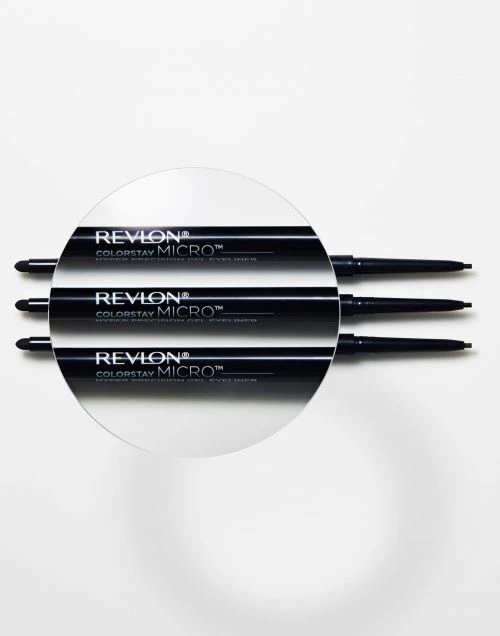 Three Revlon Colorstay Micro gel eyeliners displayed on a white surface with a magnifying glass over the center eyeliner.
