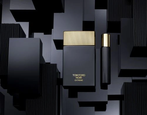 Luxury product shot featuring two sleek, black perfume bottles with gold accents against a backdrop of geometric black blocks.