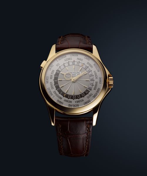 Close-up of a luxurious gold wristwatch with a brown leather band, displaying a complex dial with multiple time zones.