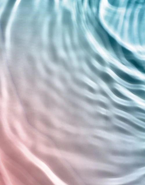 Abstract image of water with light reflections and subtle pink and blue gradient, creating a calming and serene visual texture.
