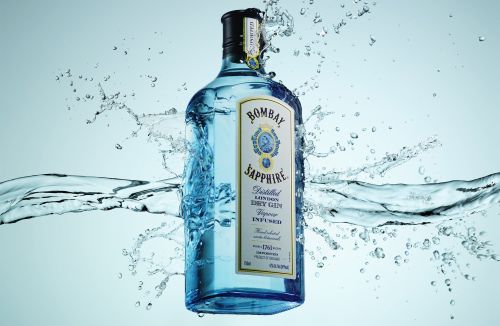 Bombay Sapphire gin bottle in water splash, close-up studio shot for beverage advertising and product promotion, clear glass bottle.