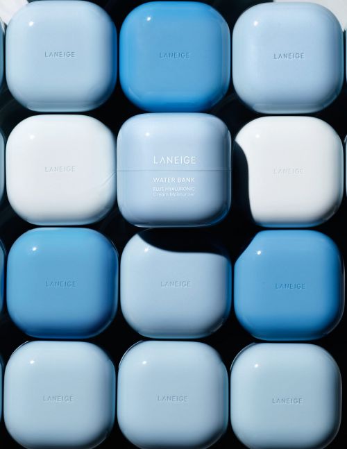 Close-up of Laneige Water Bank moisturizing cream containers in varying shades of blue and white, arranged in a grid.