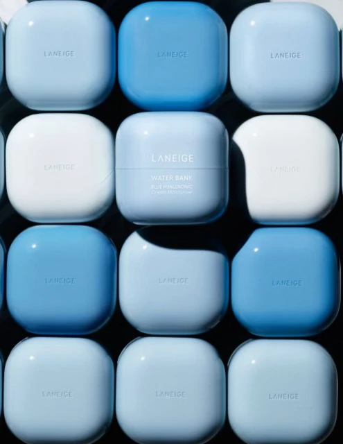 Close-up of Laneige Water Bank moisturizing cream containers in varying shades of blue and white, arranged in a grid.