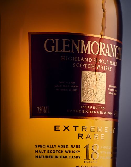 Close-up of a Glenmorangie Highland Single Malt Scotch Whisky bottle, showcasing its label with gold lettering and amber liquid inside.