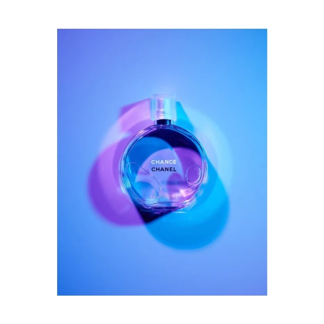 Crystal Chanel Chance perfume bottle centered with pink and blue lighting in an eye-level studio shot for beauty and fashion industries.