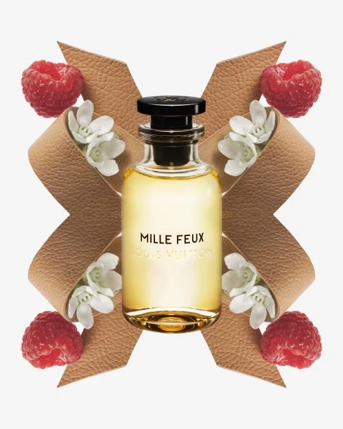Louis Vuitton Mille Feux perfume bottle on white, styled with raspberries, white flowers, and a tan leather bow for Beauty shots.