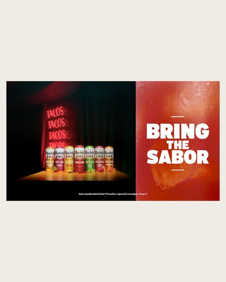 A display of Modelo beer cans in various flavors against a neon 'Tacos' sign, beside a glass of a red-orange drink.
