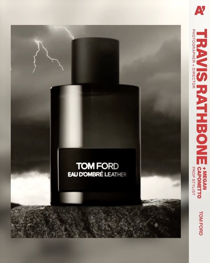 Tom Ford Eau D'Ombré Leather perfume bottle against a stormy sky backdrop on a textured rock surface, product photography.