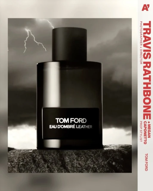 Tom Ford Eau D'Ombré Leather perfume bottle against a stormy sky backdrop on a textured rock surface, product photography.