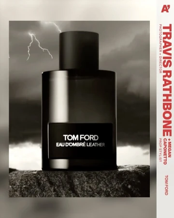 Tom Ford Eau D'Ombré Leather perfume bottle against a stormy sky backdrop on a textured rock surface, product photography.