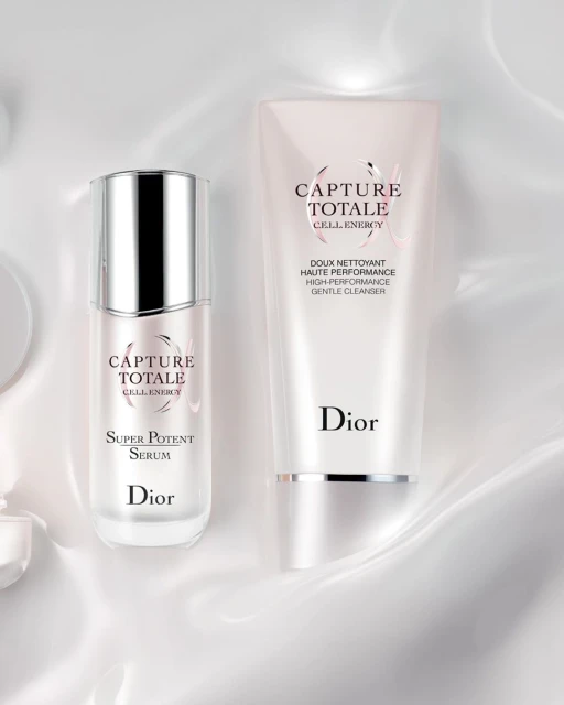 Dior Capture Totale skincare set featuring serum and cleanser against a white silky background. Cosmetic product photography.