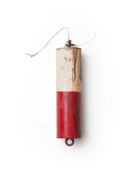 Red and white wooden buoy with aged paint, rope, and metal ring on a white background, providing a simple, nautical aesthetic.